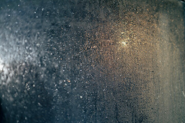window with waterdrops and dew. Car lights through the window