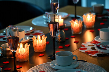 Hochzeitstisch gedeckt mit Kerzen, Herzen und Gläsern in warmen Ambiente