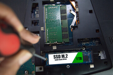 Top view of technician installing M.2 SSD hard drive.