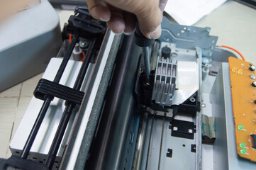 Top view of technician inspecting and repairing printer.