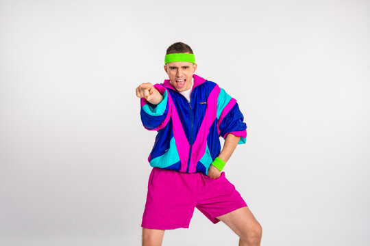 Energetic young man in vibrant 80s sportswear striking a dynamic pose against a white background. - Powered by Adobe