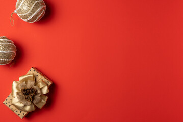 Christmas red background with gift box and balls. Flat lay, top view. Copy space