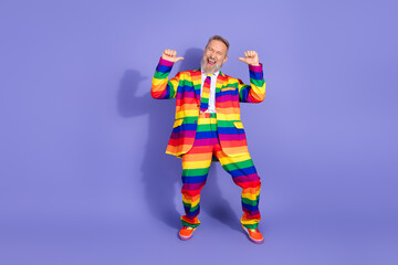 Full length photo of handsome good mood guy wear lgbtq rainbow suit pointing thumbs himself empty space isolated violet color background