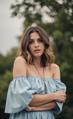 A woman in a blue dress standing with her arms crossed