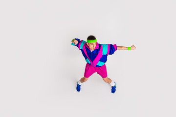 Energetic young man in retro activewear enthusiastically working out against a minimalist white background