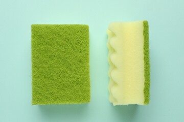 Colorful sponges on light blue background, top view