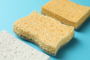 Many sponges on light blue background, closeup