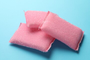 Pink sponges on light blue background, closeup