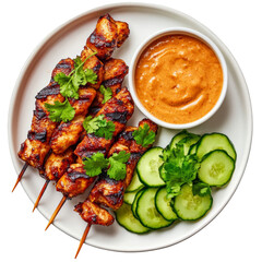 Fototapeta premium Grilled chicken skewers with peanut sauce cucumber and cilantro garnish on a white plate isolated on white background overhead view Asian cuisine meal protein rich lunch or dinner healthy food