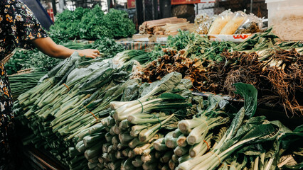 A vibrant and bustling market scene, filled with an abundance of fresh green vegetables, herbs, and lively energy