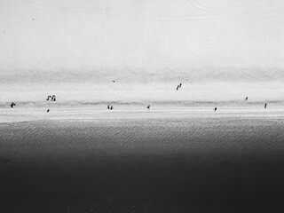 Black and white view of beach with small group of people