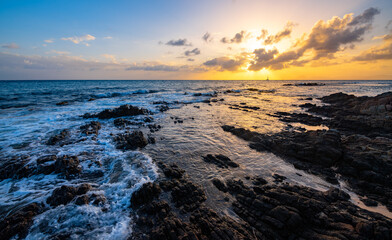 Sunset panorama at &ldquo;Grand Anse des Salines&ldquo; famous sandy beach on french tropical island Martinique in the Caribbean sea. Colorful idyllic seascape with waves, rocks, cloudy sky and warm sunlight.