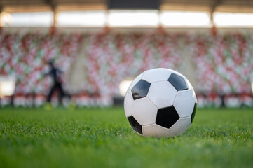 Soccer ball on the field and silhouette of player in the backgrond