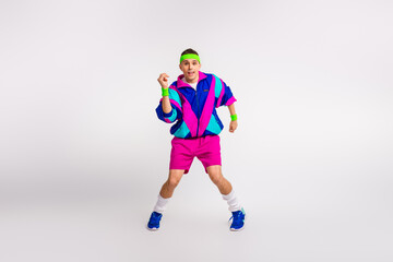 Young man in retro sportswear exercising energetically in a bright windbreaker and shorts, embodying a funky 80s style