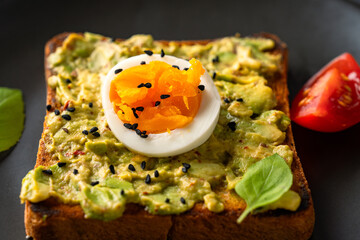 Healthy avocado toasts with eggs on black