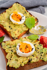 Healthy avocado toasts with eggs on black
