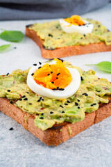Healthy avocado toasts with eggs on table