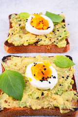 Healthy avocado toasts with eggs on table