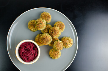 Vegetarian Cauliflower Falafel with Beetroot Dip, in a plate, on a black table, Vegan