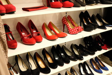 high heel shoes in red and black color on a shelf in a second hand store