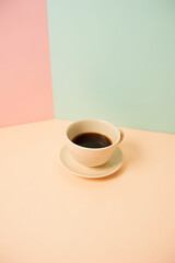 A small cup of coffee sits on a brightly colored pastel background with a subtle soft focus effect._00001_