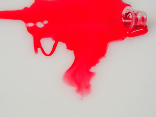 Close-up of colored bright red tattoo ink in a jar, highlighting color saturation and quality to...
