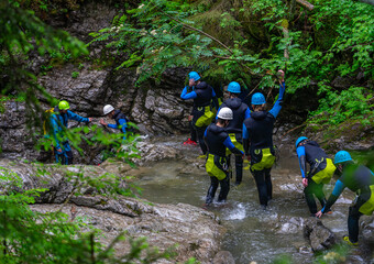 CANYONING im ALLGÄU Kleinwalsertal: Jugendliche Gruppe beim sportlichen Freizeitspass im Wasser, im Fluß, in der Schlucht