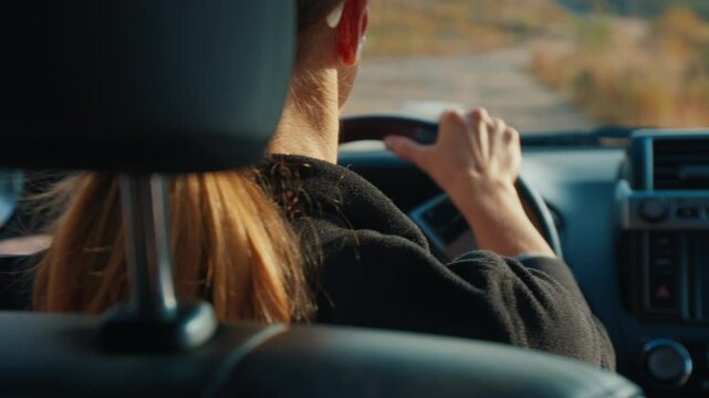 Young woman steers the big 4x4 car on a bumpy unpaved road