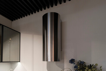 Cylinder metal kitchen hood on a wall