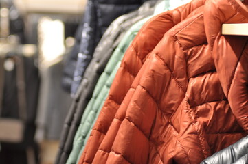 Colorful Jackets and Coats Neatly Hung on a Rack in a Fashion Store. Concept of Winter Apparel, Textile Variety, Retail Display, clothes shop, and Clothing Organization. Banner