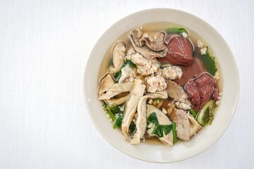 Thai Style breakfast Clear Soup with Congealed pork blood . Thai Traditional boiled soup pig blood supply on white background, top view	