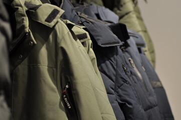 Colorful Jackets and Coats Neatly Hung on a Rack in a Fashion Store. Concept of Winter Apparel, Textile Variety, Retail Display, clothes shop, and Clothing Organization.