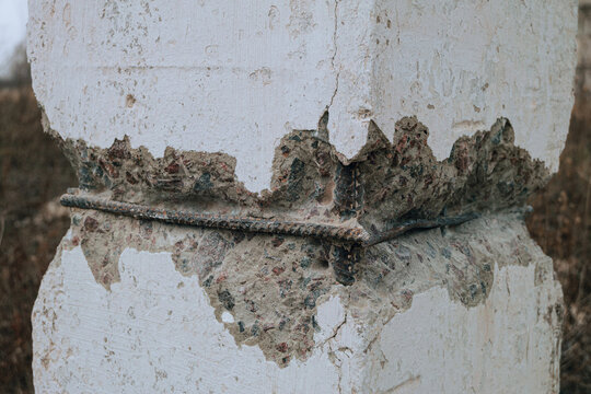 Damaged concrete construction with exposed steel reinforced rods. Engineering inspection of building structures using destructive methods.
