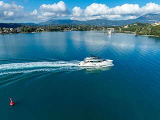 Luxury yacht cruising on turquoise water with coastal view