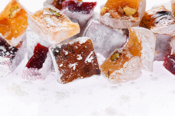 Sweet food Turkish delight, assorted rahat locum in form of cubes with nuts and powdered sugar, traditional food, on white background