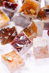 Sweet food Turkish delight, assorted rahat locum in form of cubes with nuts and powdered sugar, traditional food, on white background