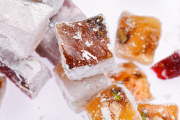 Sweet food Turkish delight, assorted rahat locum in form of cubes with nuts and powdered sugar, traditional food, on white background