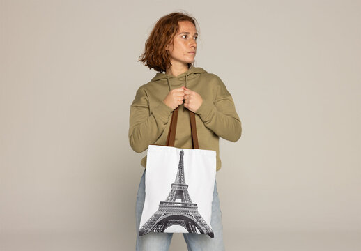 Customizable Tote Bag With a Stylish Woman Against a Neutral Backdrop.. PSD mockup. Insert your design, your logo and change color from bag