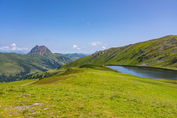 Visitors enjoy the breathtaking views of the Wildkogel water reservoir. Surrounded by the stunning peaks of the Austrian Alps, the area offers tranquility and natural beauty.