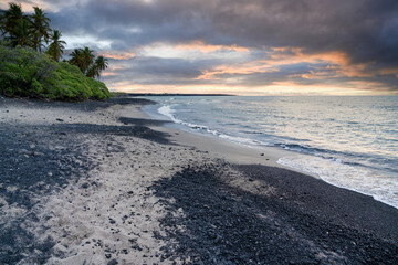 Beach with white coral sand and black volcanic sand on the shores of Big Island, Hawaii