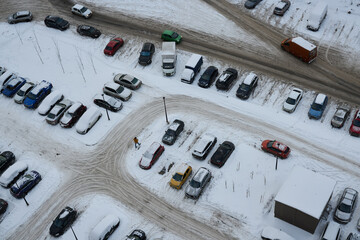 Aerial view of a snowcovered parking lot during the cold winter season showcasing vehicles,