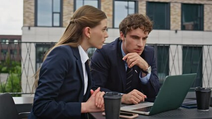Business partners failed deal looking laptop at restaurant terrace closeup.