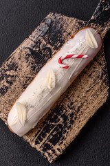 Sweet eclair with chocolate filling covered with white glaze