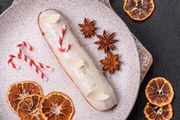 Sweet eclair with chocolate filling covered with white glaze