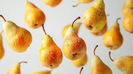 Ripe whole raw yellow pears in drops of water flying in the air, falling fresh appetizing fruits close-up isolated on white background.