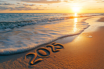 2025 written in sand with a gentle ocean wave washing over it