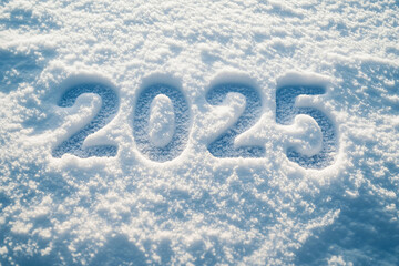The numbers 2025 neatly written in fresh snow under soft natural light