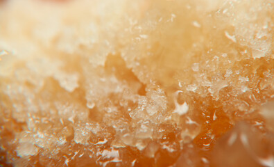 Close up of crystalline sugar on a surface highlighting texture and color variation