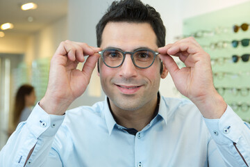 man trying on eyeglasses in a store