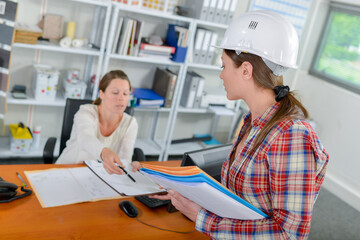 Boss handing doucument to an employee